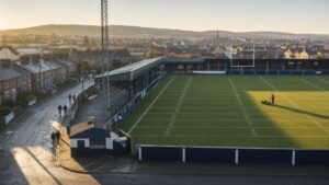 Community American football stadium overlooking a town at sunrise
